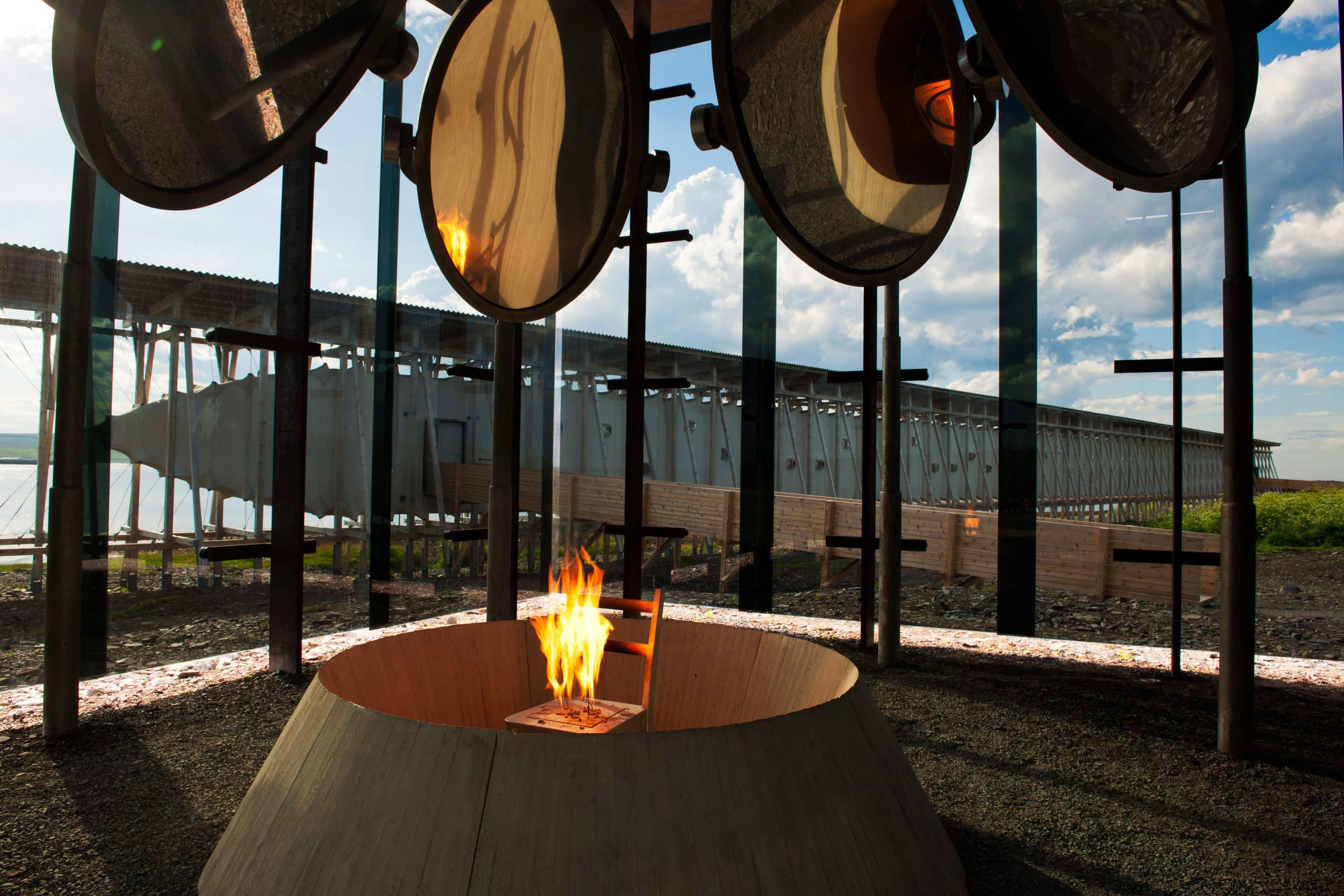 Pièce vitrée donnant sur la mer avec une chaise qui brûle au centre