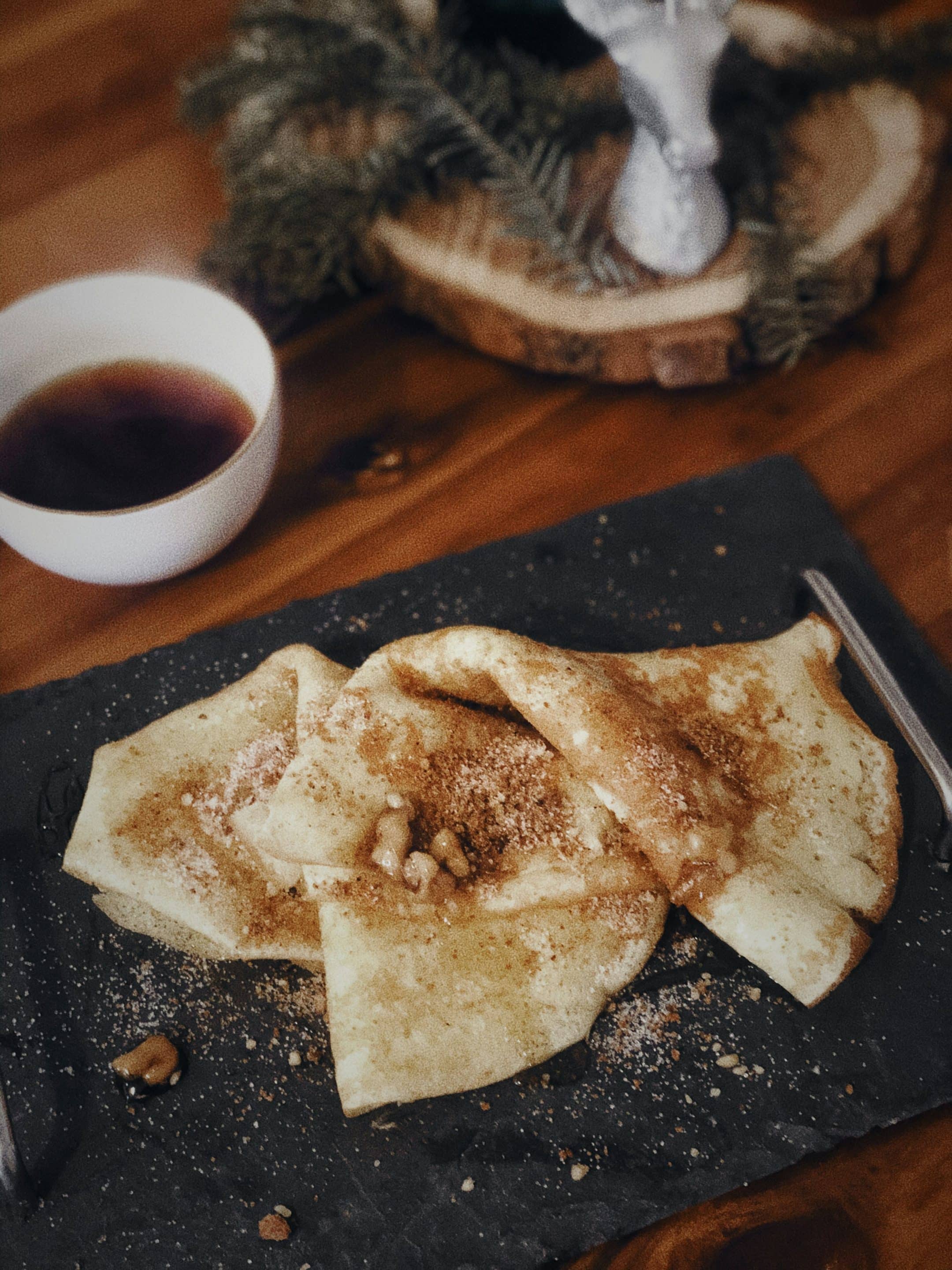 Gros plan sur une table de restaurant avec une crêpe gourmande et une tasse de thé.