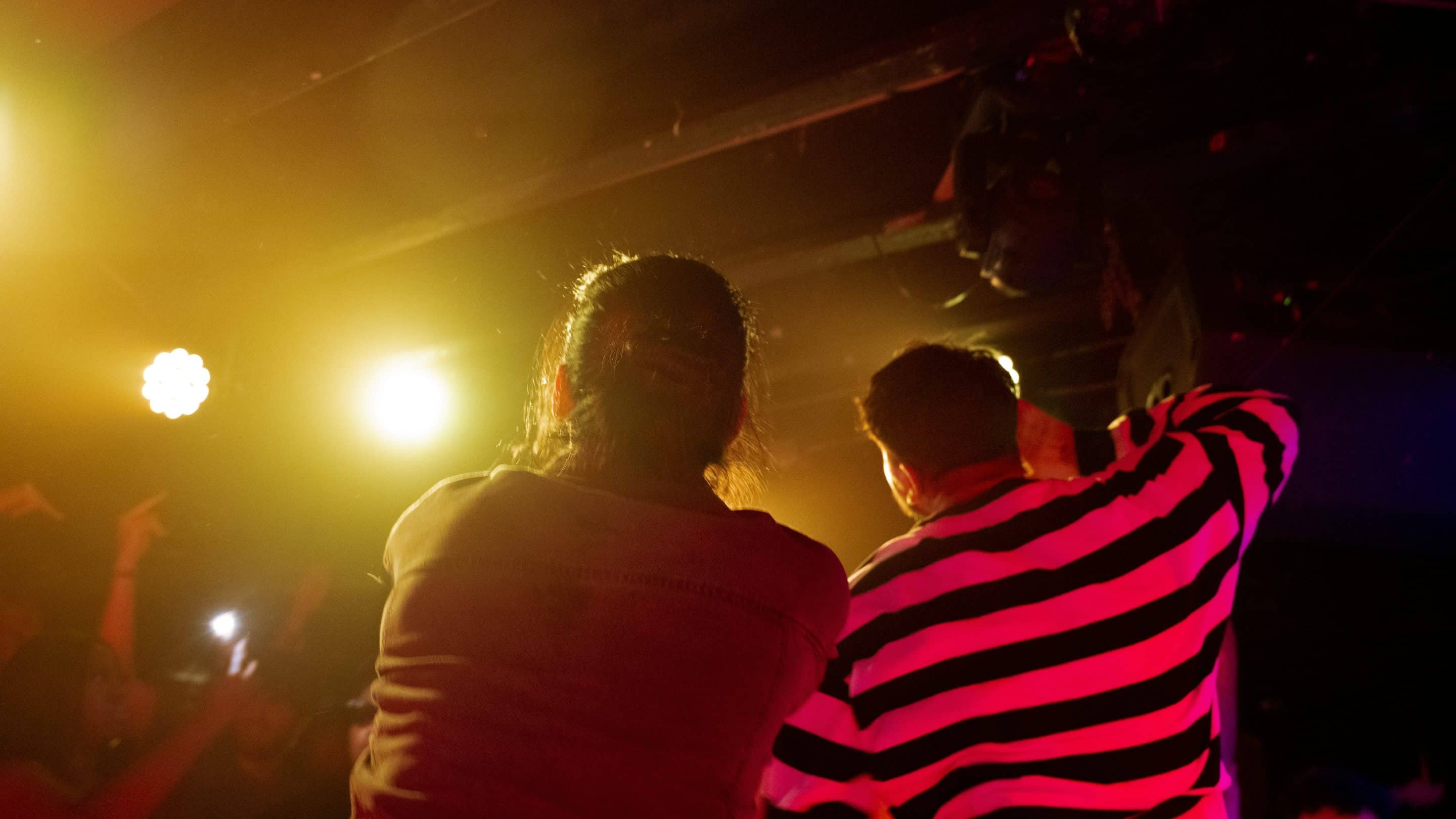 Deux personnes font la fête dans une salle avec ambiance lumineuse 