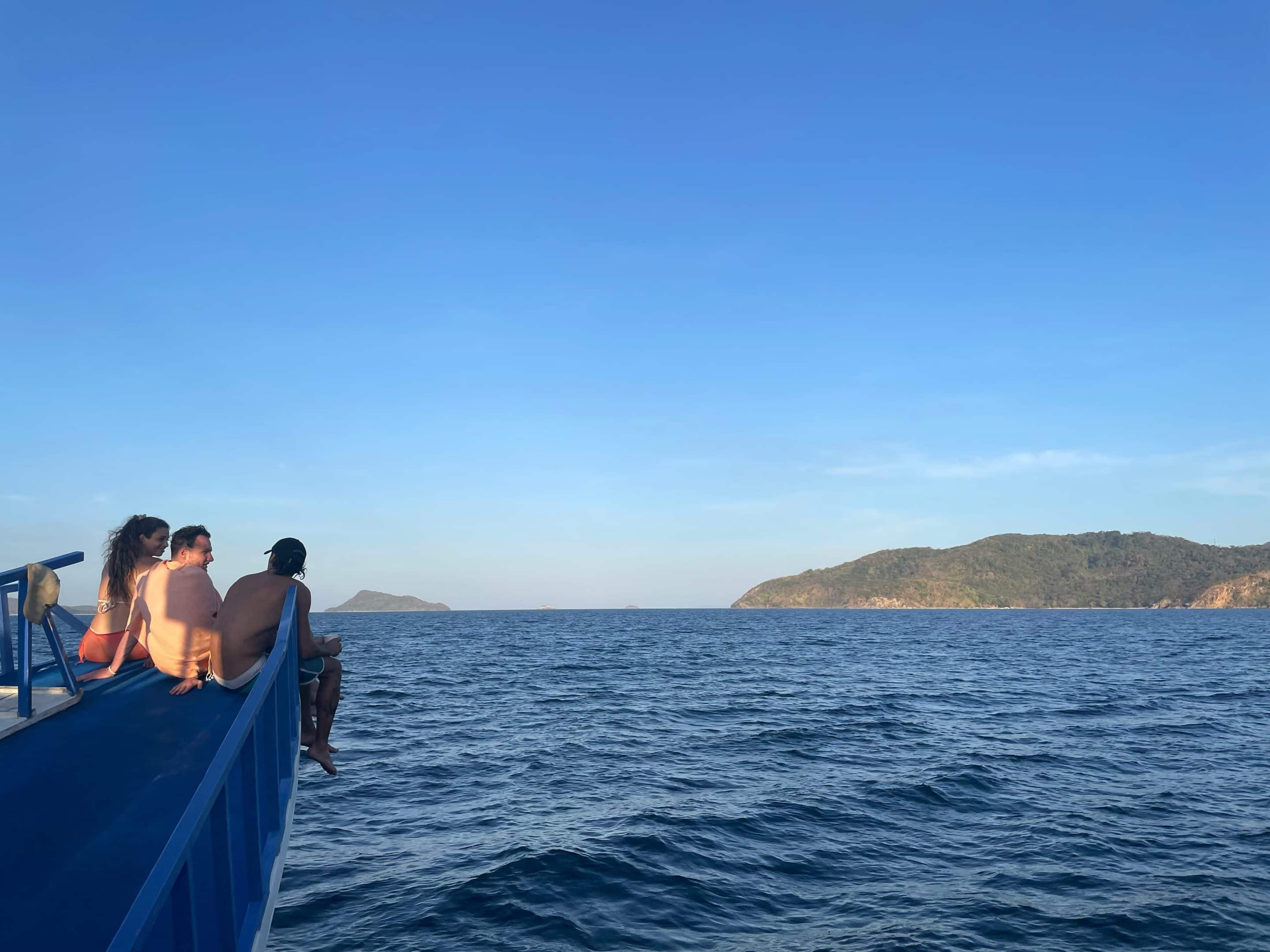 Personnes à bord d'un bateau sur la mer avec île en arrière-plan